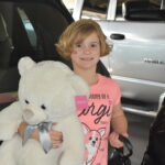 Hadley holding a large teddy bear.