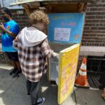 Hadley by the community fridge with it's door open.