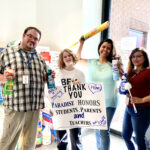 Hadley holding a poster and standing with other volunteers