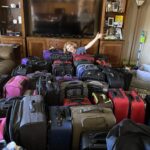 Hadley in room filled with suitcases.