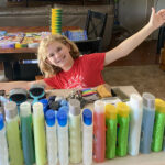 Hadley sitting with bottles of hygiene products