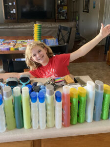 Hadley sitting with bottles of hygiene products