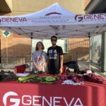 Hadley standing with volunteer at stand