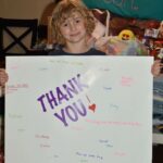 Hadley holding up a Thank You sign.