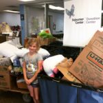 Hadley standing among boxes of donated pet supplies.