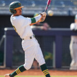 Baseball player swings a bat.