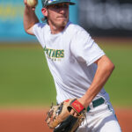 Baseball pitcher winds up to throw a pitch.